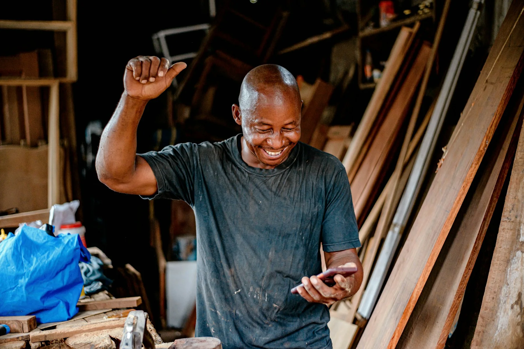 Small business owner checking his phone in a workshop